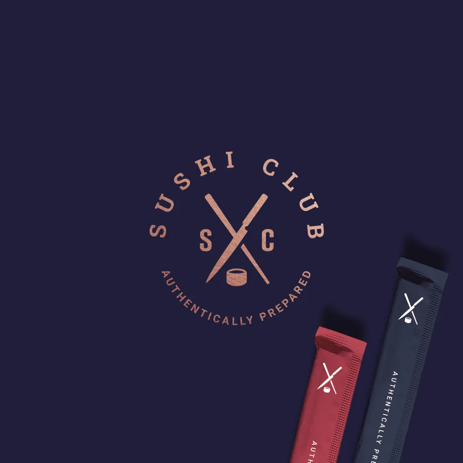 Кръглият печат на Sushi Club в медно върху тъмносин фон и опаковки за клечки