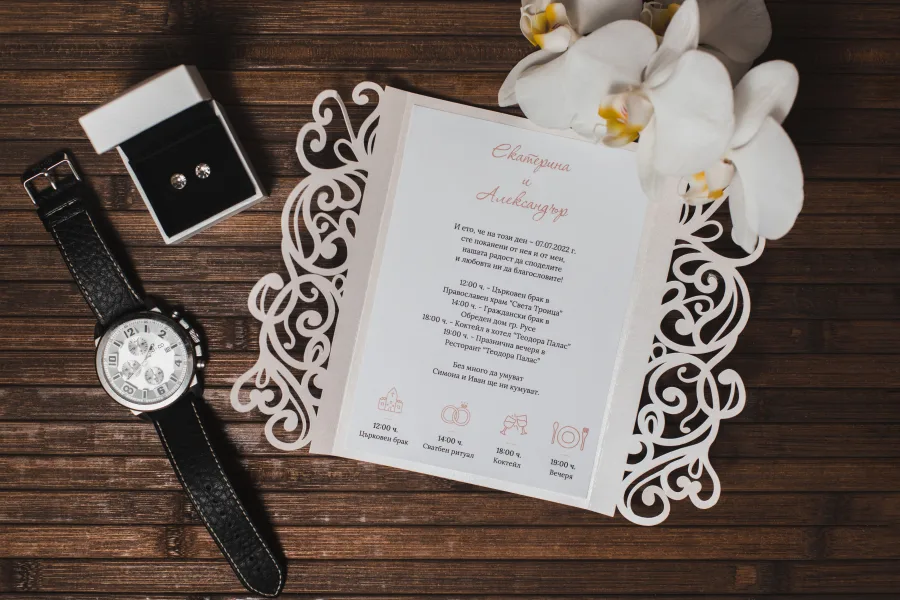 The lace-winged wedding invitation on a wooden background
